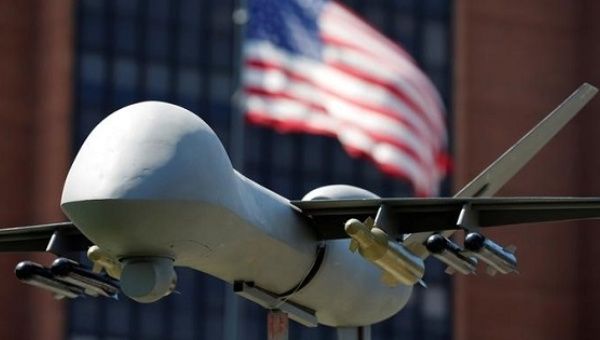 A model of a military drone is seen in front of an U.S. flag
