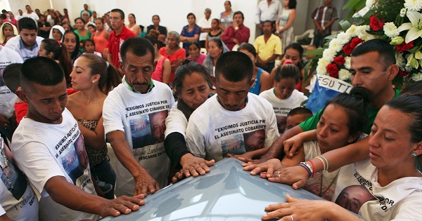 Relatives and friends of Antonio Zambrano-Montes touch his coffin during a funeral mass in Pomaro, in the Mexican state of Michoacan March 7, 2015.