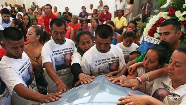 Relatives and friends of Antonio Zambrano-Montes touch his coffin during a funeral mass in Pomaro, in the Mexican state of Michoacan March 7, 2015.