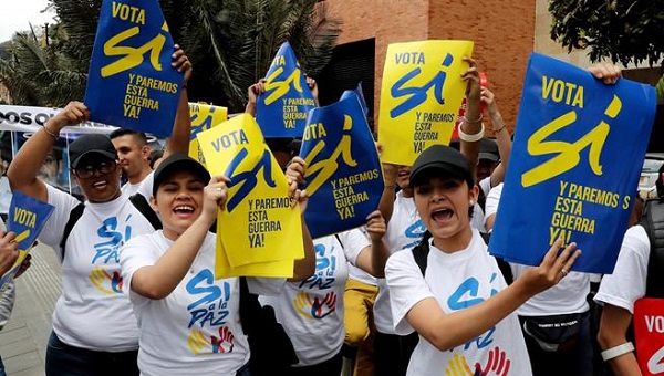 A group of Colombians hold up signs calling for a “yes” vote before an event detailing the benefits of peace in the country, Bogota, Sept. 7, 2016.