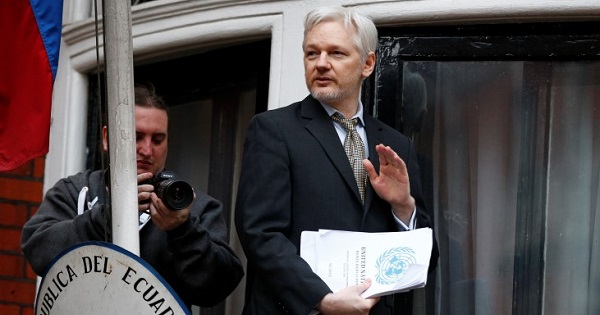 WikiLeaks founder Julian Assange holds a copy of a U.N. ruling as he makes a speech from the balcony of the Ecuadorian Embassy in London, Feb. 5, 2016.