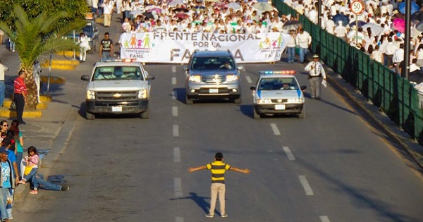 A young boy takes stands up to a bigoted march in Mexico.