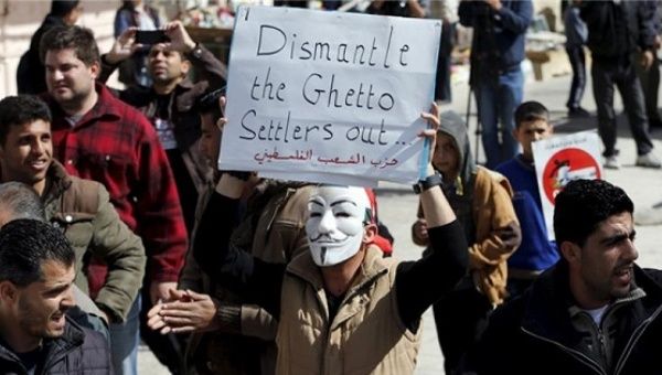 A Palestinian holds a placard during a demonstration against the closure of Shuhada street to Palestinians in Hebron.