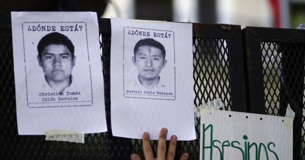 A demonstrator places pictures of some of the 43 missing students of the Ayotzinapa teachers' training college on a police fence outside Mexico's embassy in Buenos Aires October 22, 2014.