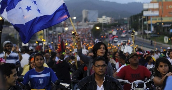 A woman holds a Honduras flag in a march demanding the resignation of President Juan Orlando Hernandez in Tegucigalpa, July 3, 2015.