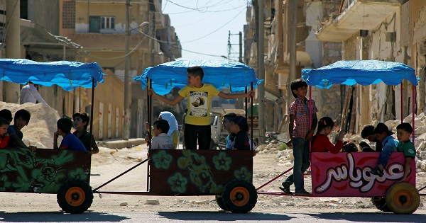 Children ride in carts on the third day of Eid al-Adha in the rebel-controlled city of Idlib, Syria Sept. 14, 2016.