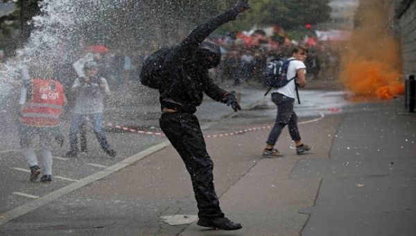 Masked protesters clash with French riot police as they take part in a march against the new French labour law, Sept. 15, 2016. 