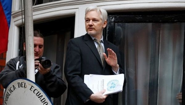 WikiLeaks founder Julian Assange holds a copy of a U.N. ruling as he makes a speech from the balcony of the Ecuadorian Embassy, in central London, Britain Feb. 5, 2016. 