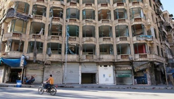 A man rides a motorcycle past a damaged building in the rebel-held al-Shaar neighbourhood of Aleppo, Syria, September 17, 2016. 