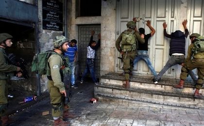 Israeli soldiers search Palestinians during clashes in the West Bank city of Hebron, Sept. 19, 2016.