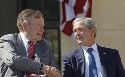 Former U.S. President George W. Bush (R) shakes hands with his father, former President George H.W. Bush, Dallas, Texas April 25, 2013. 