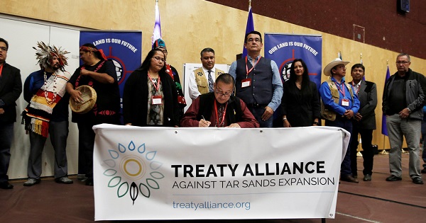 Grand Chief Stewart Phillip signs the Treaty Alliance Against Tar Sands Expansion with other First Nations leaders in Vancouver, Sept. 22, 2016.