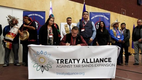 Grand Chief Stewart Phillip signs the Treaty Alliance Against Tar Sands Expansion with other First Nations leaders in Vancouver, Sept. 22, 2016. 