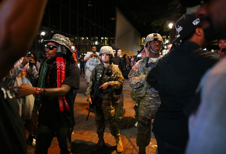 National Guard soldiers stand among protesters during another night of protests over the police shooting of Keith Scott in Charlotte, North Carolina, Sept. 22, 2016.
