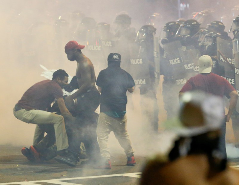 People maneuver amongst tear gas in uptown Charlotte, NC during a protest of the police shooting of Keith Scott, in Charlotte, North Carolina, Sept. 21, 2016. 