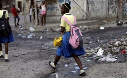 A school girl steps over a puddle in Port-au-Prince, Haiti, January 2016.