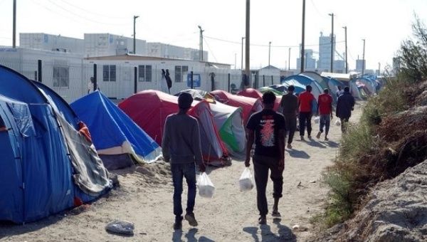 Migrants walk in the northern area of the camp called the 