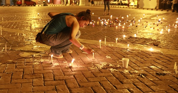 A person lights candles for peace in Cartagena ahead of the signing of Colombia's peace deal.