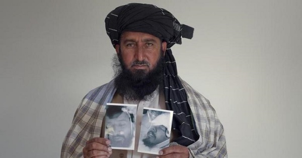 Karim Khan, 43, poses with images of his deceased brother Asif Iqbal (L) and son Zaenullah, Nov. 30, 2010.