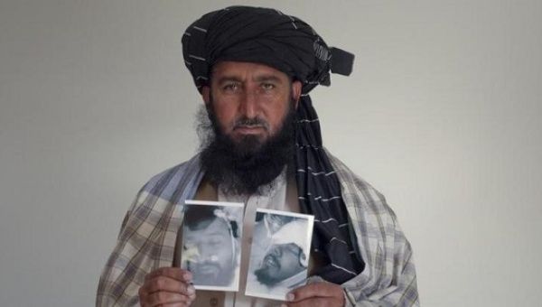 Karim Khan, 43, poses with images of his deceased brother Asif Iqbal (L) and son Zaenullah, Nov. 30, 2010. 