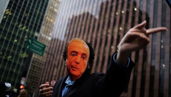 A student wears a mask depicting Brazil's President Michel Temer during a demonstration against him in Sao Paulo.
