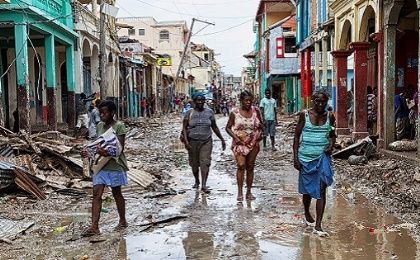 People walk along a street in downtown as clean up from Hurricane Matthew continues in Jeremie, Haiti, October 6, 2016. Picture taken October 6, 2016.