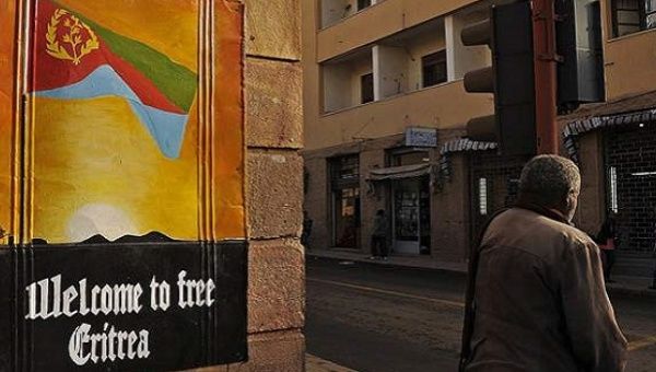 Man walks by sign in Eritrea.