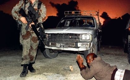 A Somali driver is ordered to lie on the ground as U.S. marines establish security in the port of Mogadishu, Dec. 9, 1992. 