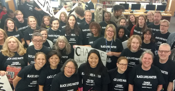 Teachers at a Seattle school pose for a photo as they sport Black Lives Matter shirts and banners.