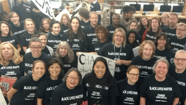 Teachers at a Seattle school pose for a photo as they sport Black Lives Matter shirts and banners. 