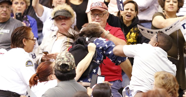 A member of the audience throws a punch at a protester as Republican presidential candidate Donald Trump speaks during a campaign event in Tucson, Arizona.