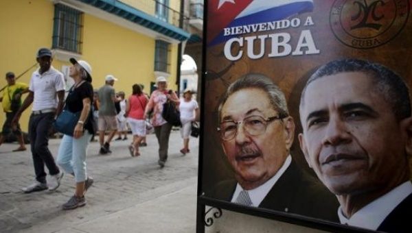 Tourists pass by images of U.S. President Barack Obama and Cuban President Raul Castro, Havana, Mar. 17, 2016. 