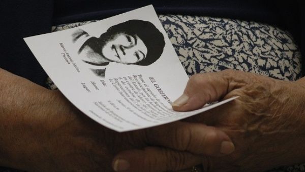 A family member holds an image of Marco Antonio Molina Theissen, kidnapped and disappeared in 1981 when he was 14 years old.