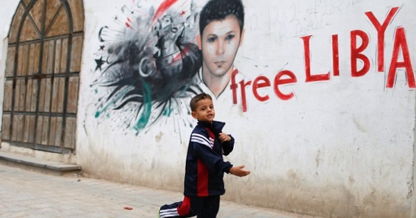 A child runs past graffiti at the old city in Tripoli.