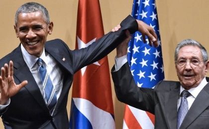 Cuban President Raul Castro raises U.S. President Barack Obama's hand during a meeting at the Revolution Palace in Havana.