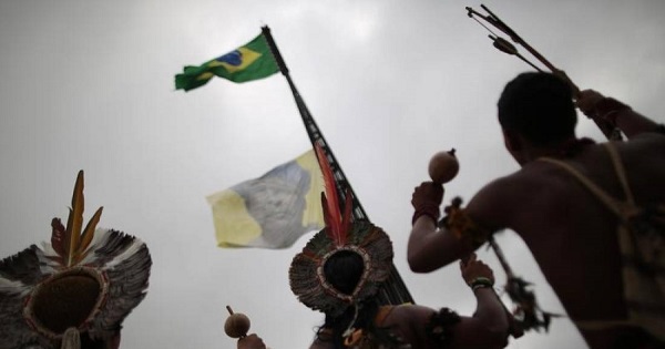 Indigenous from various parts of Brazil watch the hoisting of a flag with an image of Indian leader Arnaldo Kaba of the village Mundurukoe, during a demonstration to defend the territorial rights of the Indigenous population against the government, agribusiness and large mining and energy companies.