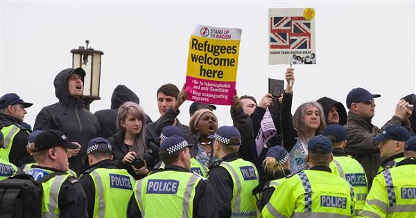 Anti-racism demonstrators hold up placards and chant slogans as a far-right group marches through Dover, southern England, on April 2, 2016.