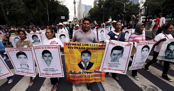 Relatives carry photos of the 43 missing students of the Ayotzinapa teachers' college during a protest in Mexico City, Aug. 26, 2015.