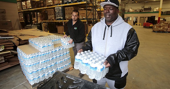 Man picks up bottled water from the Food Bank of Eastern Michigan to deliver to a school after elevated lead levels were found in the city's water in Flint, Michigan.