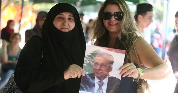 Women carry a picture of newly elected Lebanese President Michel Aoun in the Haret Hreik area, southern suburbs of Beirut, Lebanon, Oct. 31, 2016.