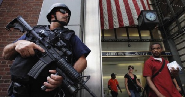 Members of the public react as they walk past an NYPD Hercules team on patrol near Penn Station in New York City.