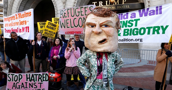 Demonstrators protest against Donald Trump on the sidewalk, outside the grand opening of his new Trump International Hotel in Washington, Oct. 26, 2016.