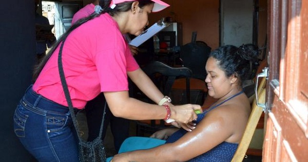 A health worker sprays mosquito repellent on a pregnant woman during a campaign to fight the Zika virus, Colombia, Feb. 1, 2016.