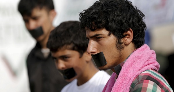 Refugees with their mouths taped stage a protest at a makeshift camp at the Greek-Macedonian border near the village of Idomeni, Greece, April 1, 2016.
