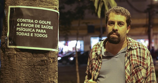 Leader of Brazil's homeless movement MTST, Guilherme Boulos, poses next to a sign that reads 