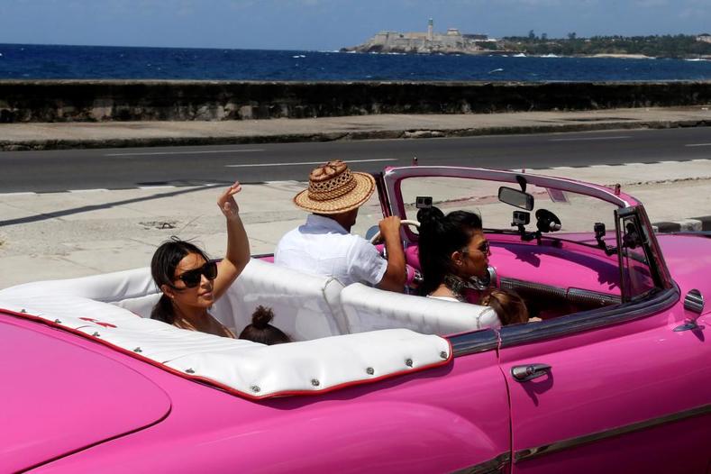 Kim Kardashian waves from the backseat of a vintage car at the seafront Malecon in Havana, Cuba, May 5, 2016. 