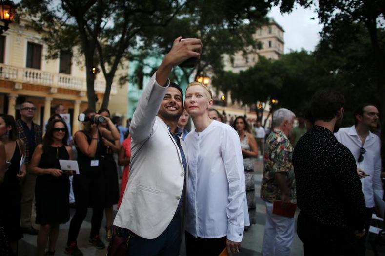 Tilda Swinton takes a picture with a guest prior to the Chanel fashion show in Havana, Cuba, May 3, 2016. 