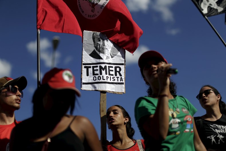 Members of social movements hold signs during a protest against Brazil's Vice President Michel Temer in front of Jaburu Palace in Brasilia, Brazil April 23, 2016. The placard reads: 