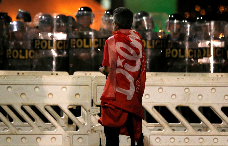 A demonstrator stands in front of police officers during a protest against the impeachment of President Dilma Rousseff in Brasilia, Brazil, May 11, 2016.