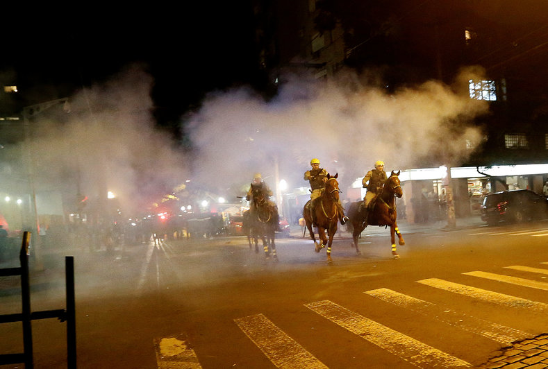 Policemen ride their horses during a clash with demonstrators at a protest against the impeachment of President Dilma Rousseff, in Porto Alegre, Brazil, May 12, 2016. 
